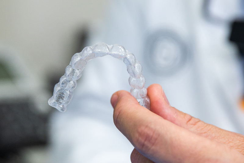 Invisalign retainer being held by dentist