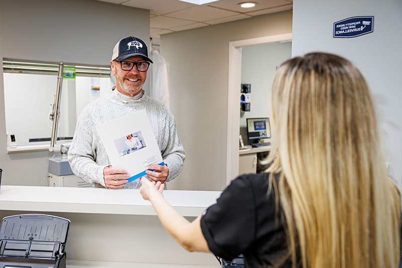 patient being helped at the front of the desk of the dental center